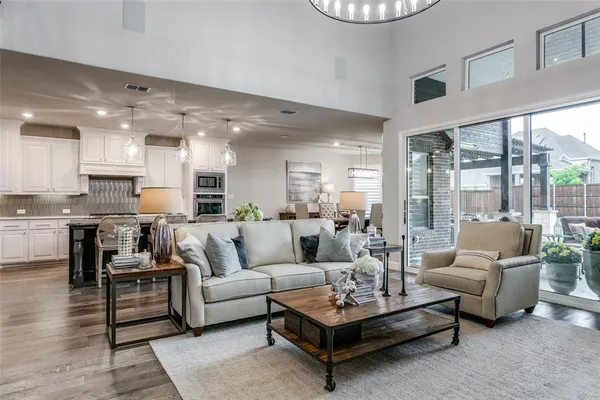 a living room with furniture kitchen view and a large window