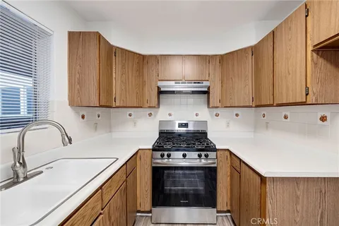a kitchen with stainless steel appliances granite countertop a sink stove and cabinets
