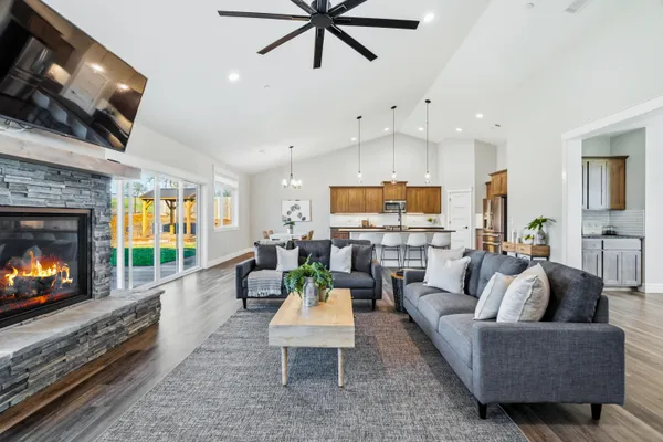 a view of a dining room and livingroom with furniture wooden floor a chandelier