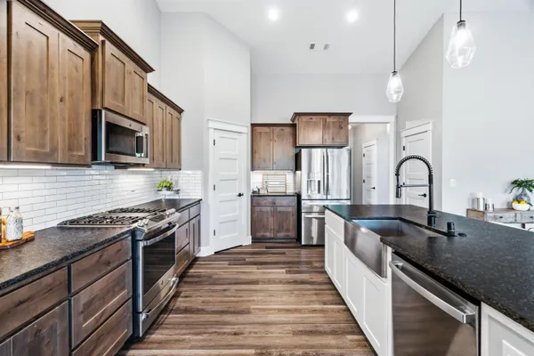 a kitchen with granite countertop a table chairs microwave and cabinets