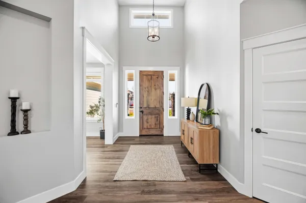 a living room with furniture kitchen view and a wooden floor