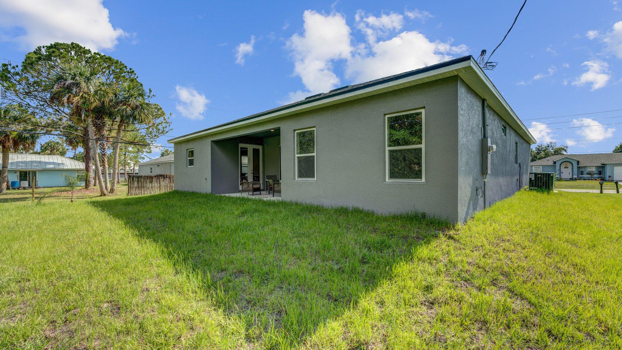 933 Tupelo Road Southwest Palm Bay, FL 32908 - Photo 30 of 31 a backyard of a house with table and chairs