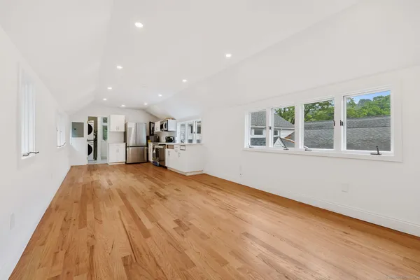a view of empty room with wooden floor and windows