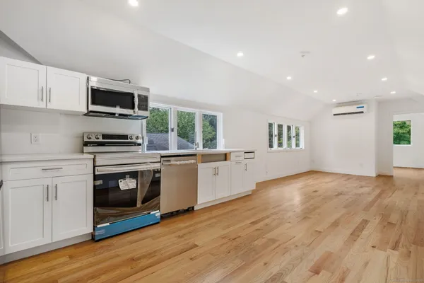 a kitchen with stainless steel appliances granite countertop a stove a sink and a microwave