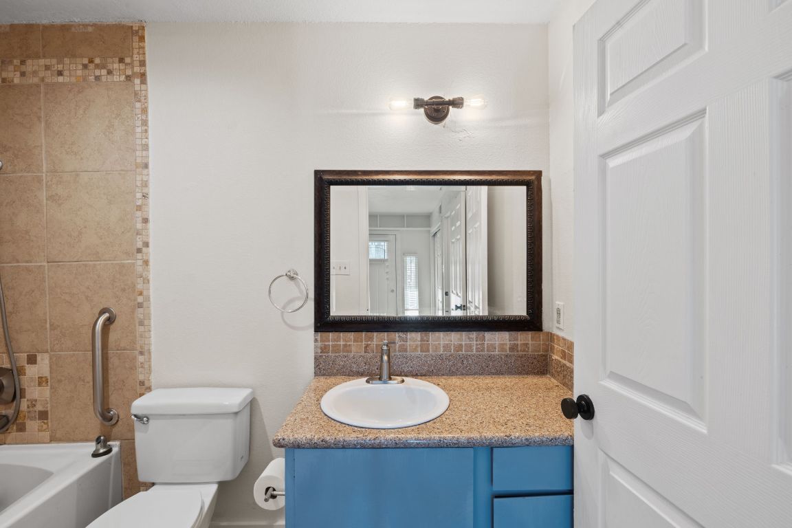 1705 Crossing Place, Unit 117B Austin, TX 78741 - Photo 27 of 33 a bathroom with a toilet sink and mirror