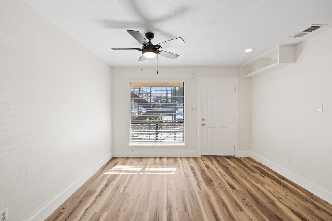 1705 Crossing Place, Unit 117B Austin, TX 78741 - Photo 3 of 33 an empty room with wooden floor fan and windows