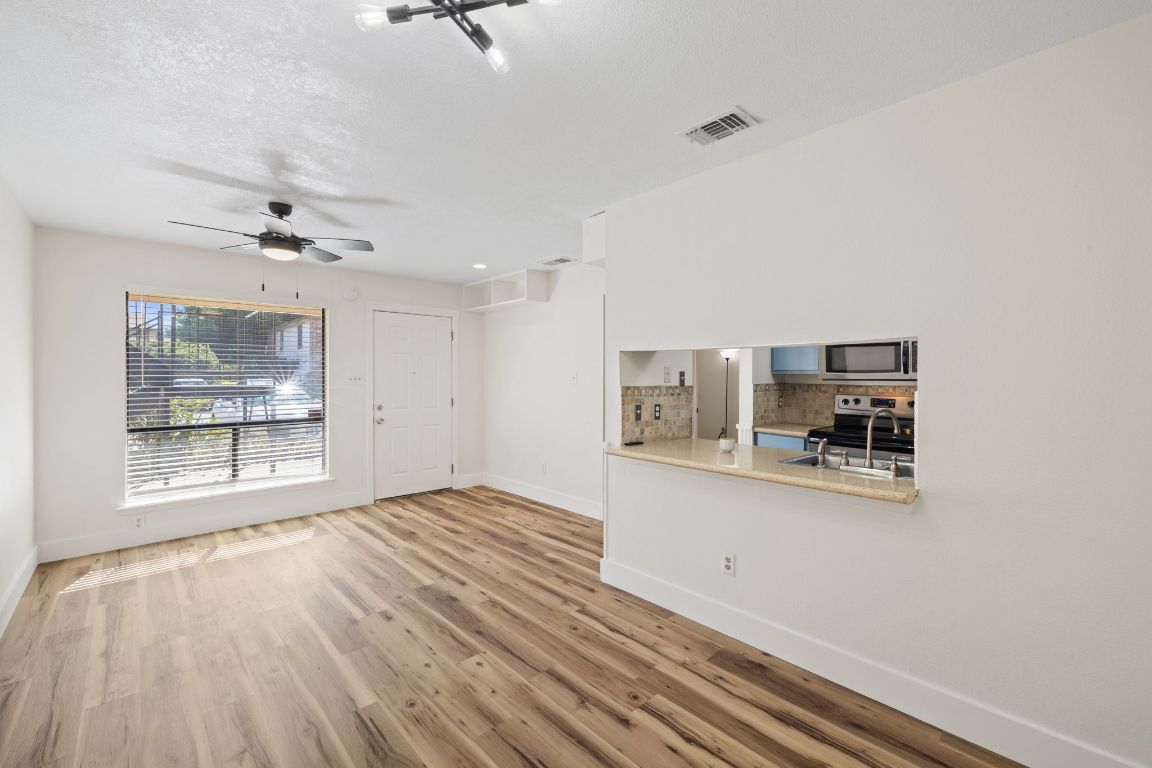 1705 Crossing Place, Unit 117B Austin, TX 78741 - Photo 4 of 33 a view of a room with wooden floor and white walls