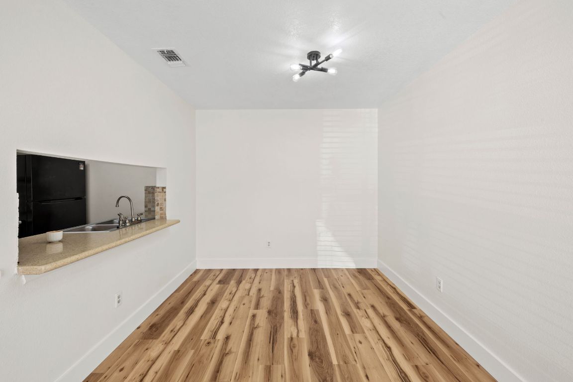 1705 Crossing Place, Unit 117B Austin, TX 78741 - Photo 6 of 33 a view of a room with wooden floor and cabinet