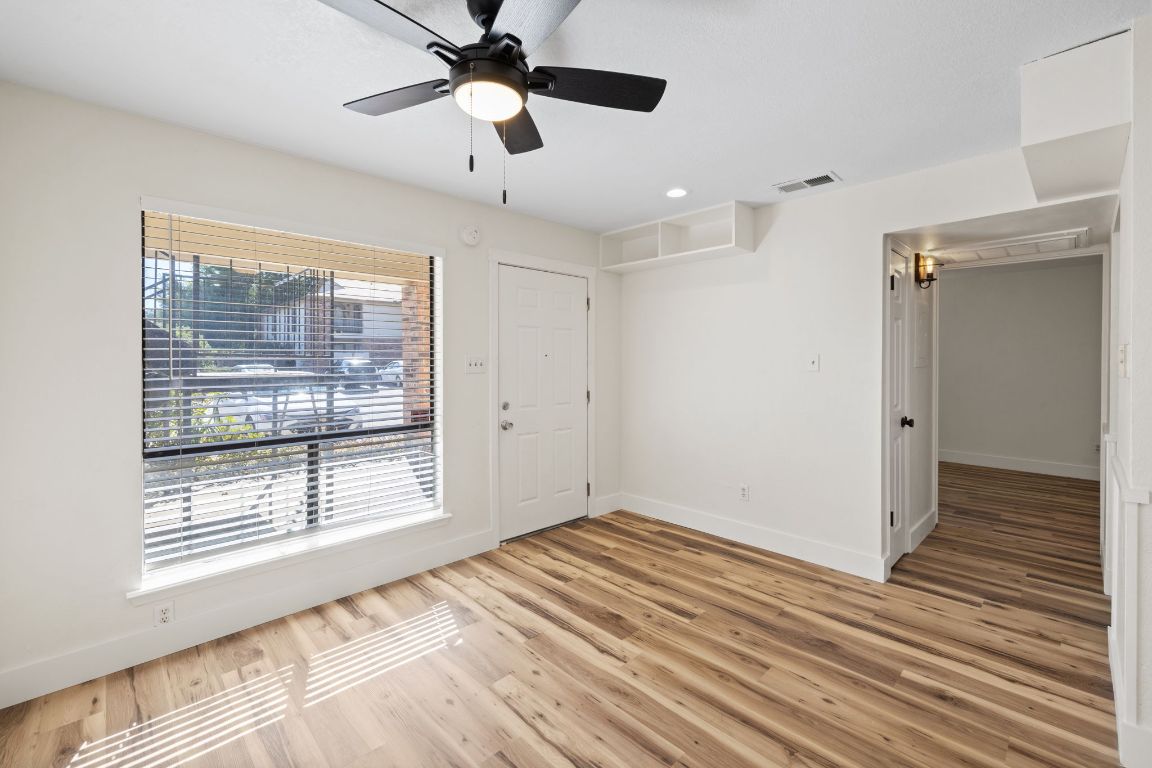 1705 Crossing Place, Unit 117B Austin, TX 78741 - Photo 8 of 33 a view of an empty room with a window and wooden floor