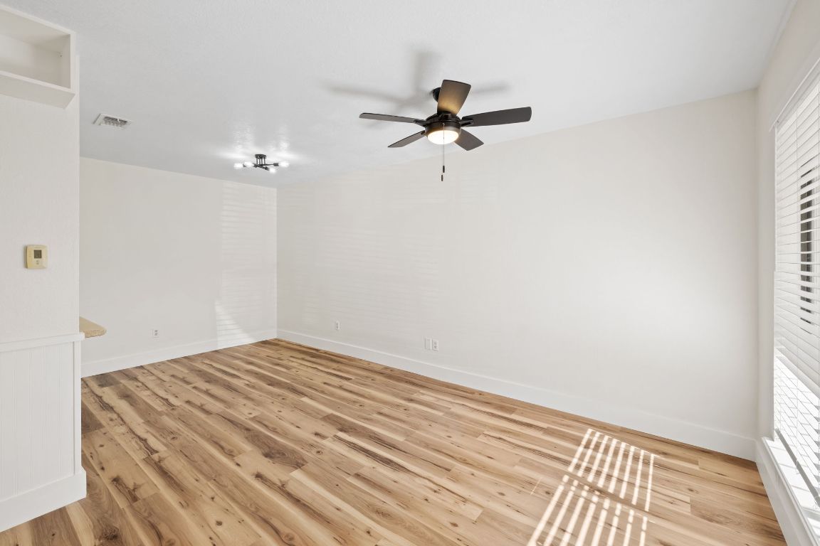 1705 Crossing Place, Unit 117B Austin, TX 78741 - Photo 9 of 33 a view of a room with a hanging light and hardwood floor