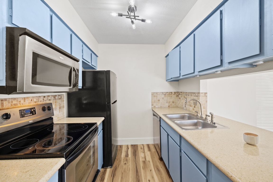 1705 Crossing Place, Unit 117B Austin, TX 78741 - Photo 10 of 33 a kitchen with stainless steel appliances granite countertop a sink stove and refrigerator