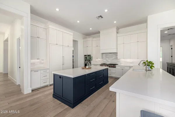 a bedroom with a bed and a lamp on dresser