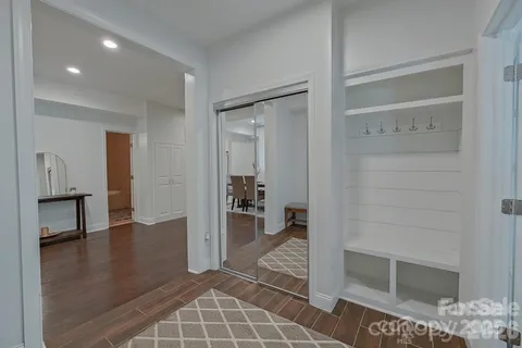 a view of a hallway with wooden floor and a bathroom