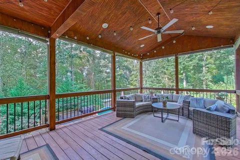 a balcony with wooden floor and outdoor seating