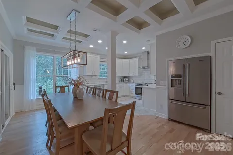 a kitchen with a dining table chairs refrigerator and microwave