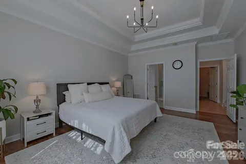 a bedroom with a large bed and a chandelier