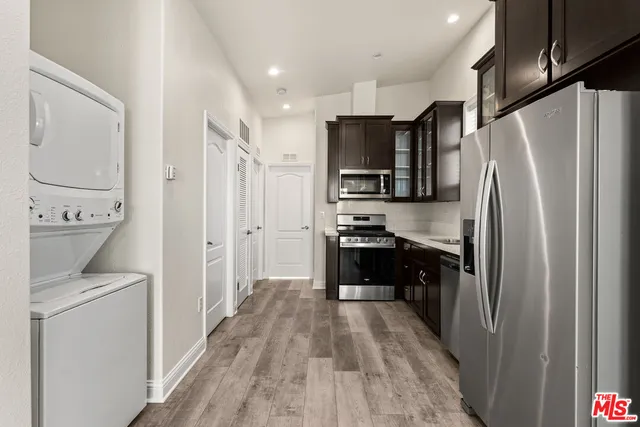 a kitchen with a refrigerator a stove top oven and wooden floor