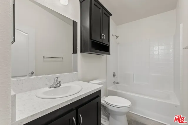 a bathroom with a sink toilet a mirror and shower