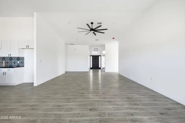 a large kitchen with granite countertop a sink cabinets and wooden floor