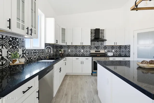 a kitchen with granite countertop a sink a counter space appliances and cabinets