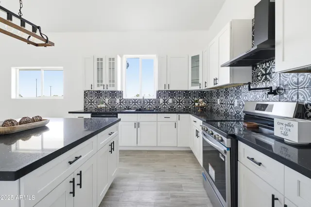 a kitchen with stainless steel appliances granite countertop a sink stove and cabinets