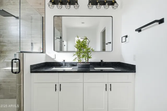 a bathroom with a granite countertop sink mirror and shower