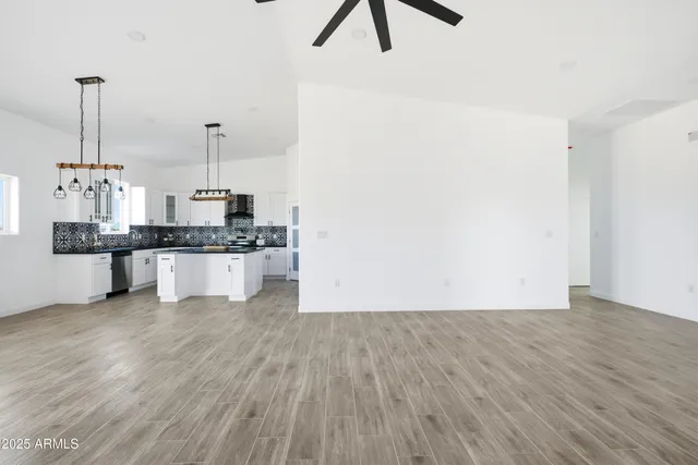 a view of a room with wooden floor and ceiling fan