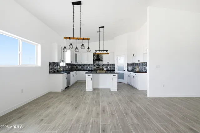 a view of a kitchen with granite countertop stainless steel appliances and wooden floor