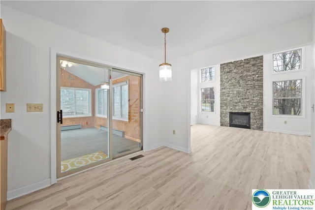 a view of an empty room with glass door and windows