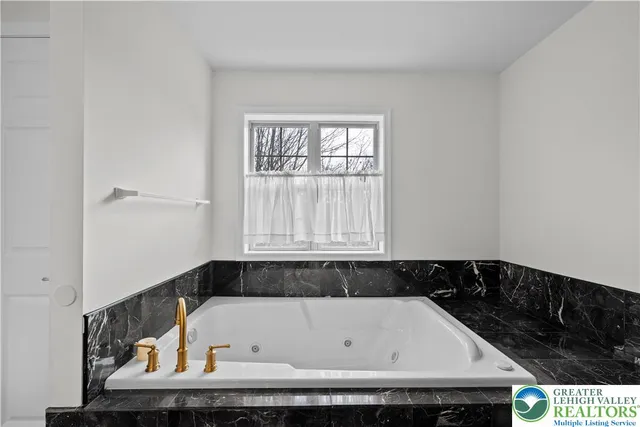 a bathroom with a bathtub and a window