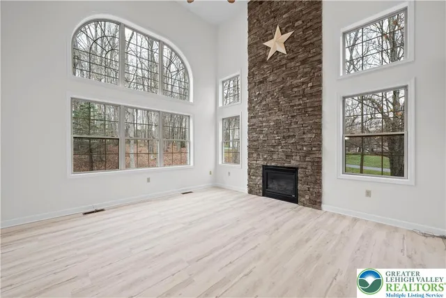 a view of an empty room with a window and fireplace