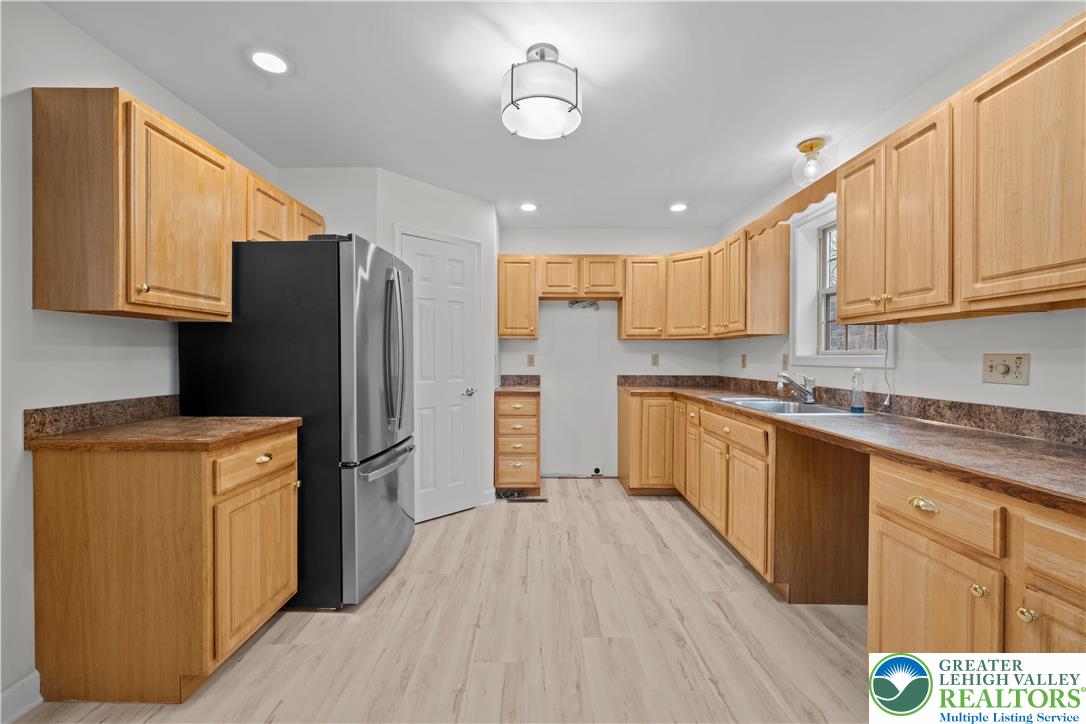 2 Pinewood Circle Hazleton, PA 18202 - Photo 10 of 34 a kitchen with stainless steel appliances granite countertop a refrigerator a sink dishwasher and wooden cabinets with wooden floor