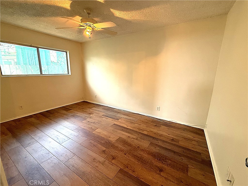6652 Valmont Street Tujunga, CA 91042 - Photo 10 of 16 an empty room with wooden floor fan and windows