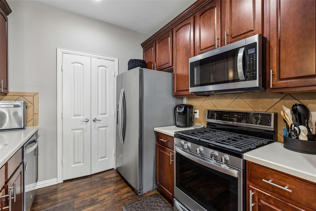 5500 Conch Train Road McKinney, TX 75070 - Photo 6 of 34 a kitchen with wooden cabinets and a stove top oven