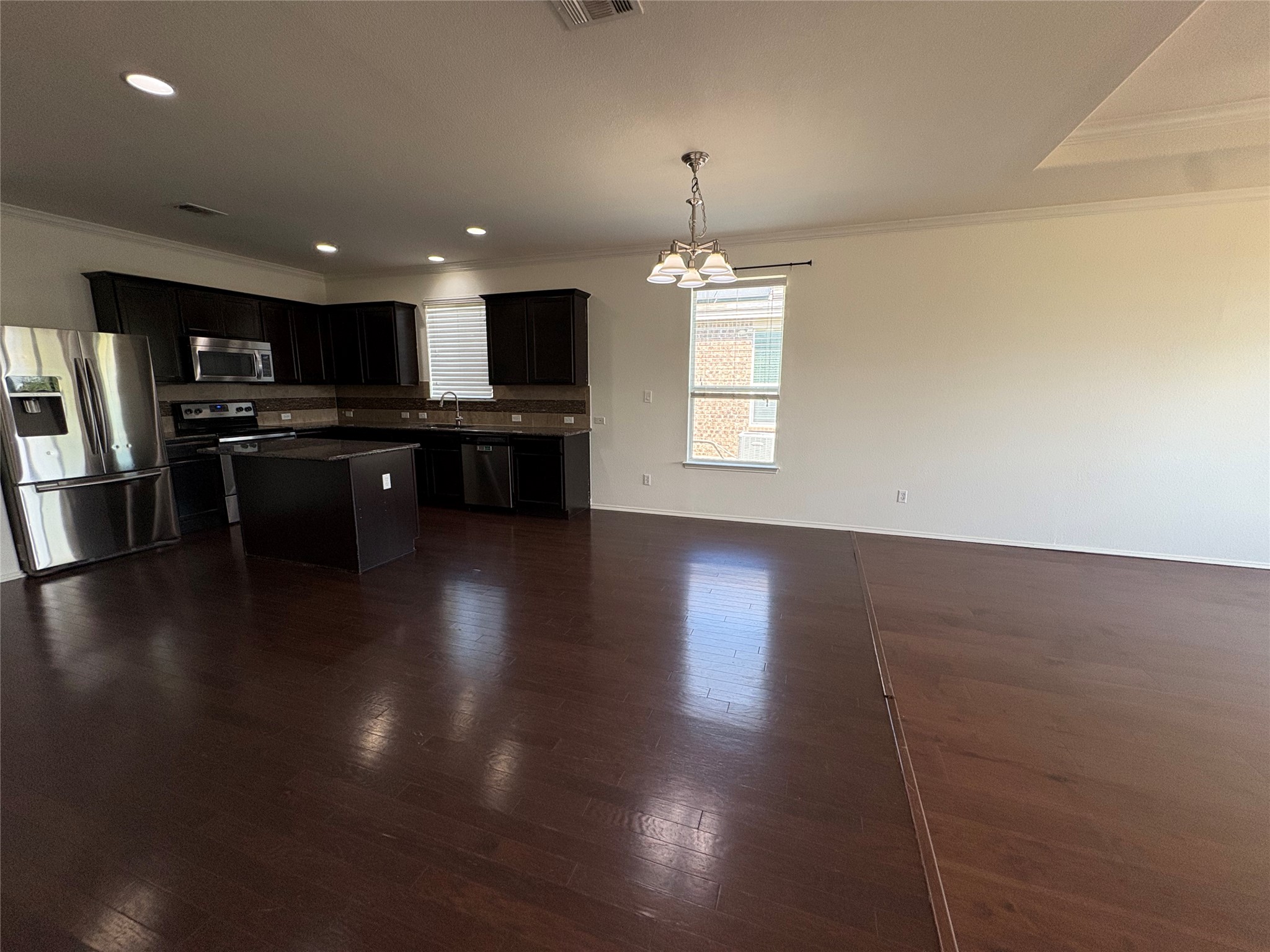 11617 Murron Drive Austin, TX 78754 - Photo 11 of 30 a open kitchen with stainless steel appliances granite countertop a refrigerator a sink a stove and a wooden floors