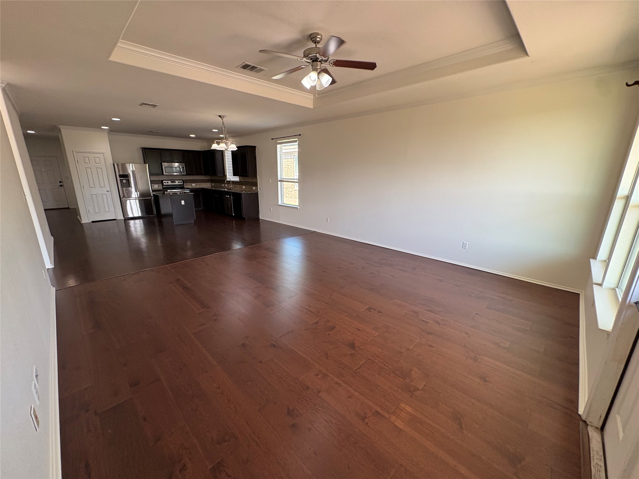 11617 Murron Drive Austin, TX 78754 - Photo 13 of 30 an empty room with wooden floor chandelier fan and windows