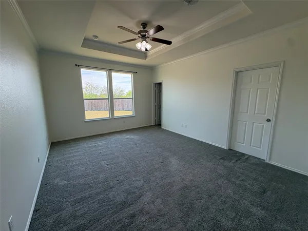 an empty room with a window and a ceiling fan