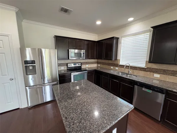 an empty room with windows and ceiling fan