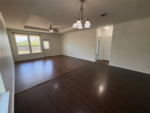 an empty room with a ceiling fan and carpet