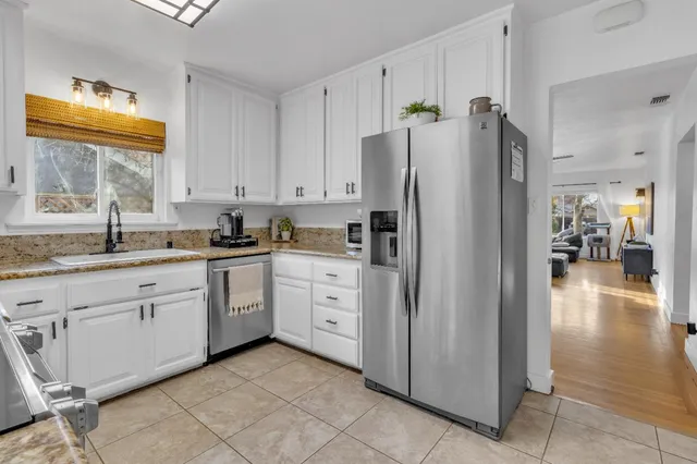 a kitchen with stainless steel appliances granite countertop a sink and dishwasher a stove top oven with wooden floor
