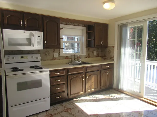 a kitchen with a stove sink and cabinets