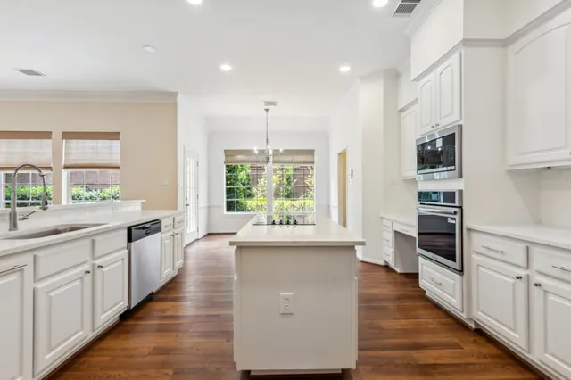 a dining room with wooden floor a chandelier a wooden table and chairs