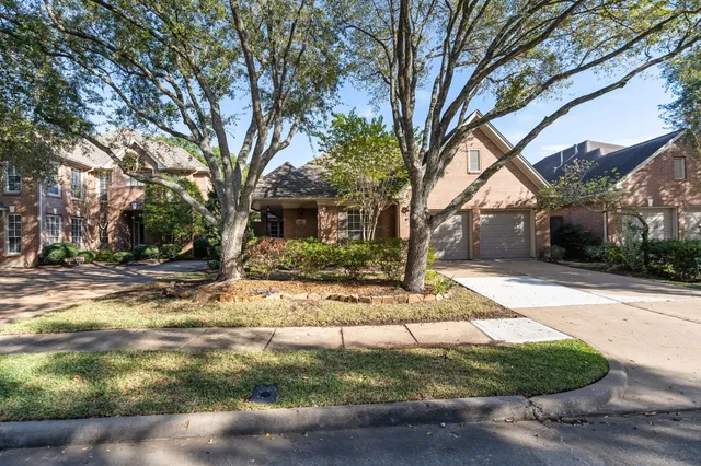 a view of a house with backyard and trees