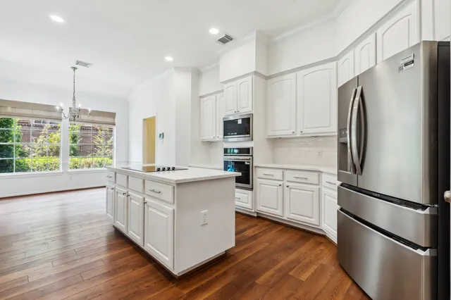 a kitchen with stainless steel appliances a stove refrigerator sink and microwave