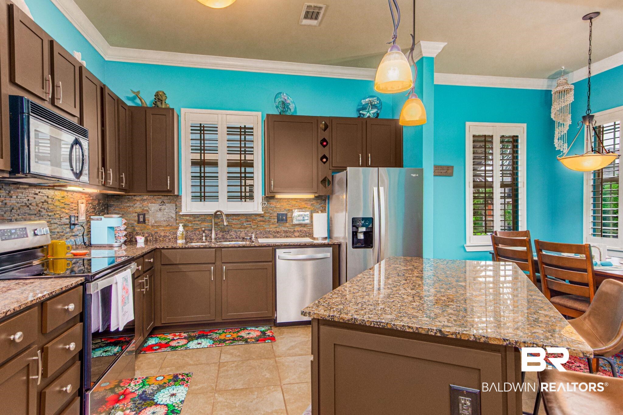 1430 Regency Road, Unit I201 Gulf Shores, AL 36542 - Photo 3 of 34 Kitchen featuring appliances with stainless steel finishes, a center island, ornamental molding, sink, and light stone counters