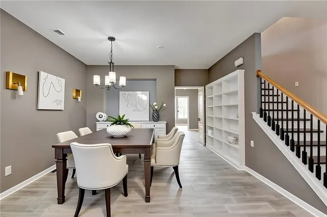 a dining room with furniture a chandelier and wooden floor
