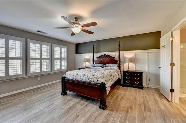 a bedroom with a large bed and a chandelier