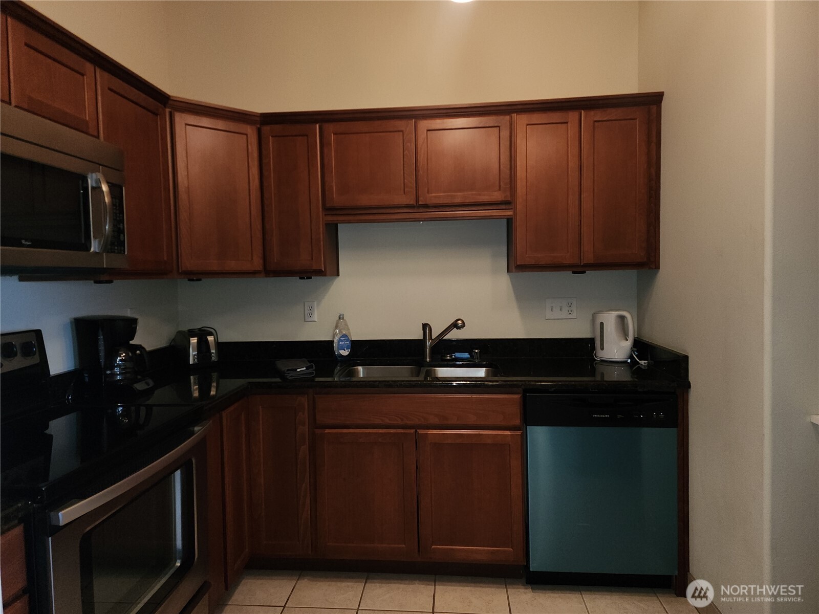 18350 Highway 3 Allyn, WA 98524 - Photo 12 of 18 a kitchen with granite countertop wooden cabinets and black appliances