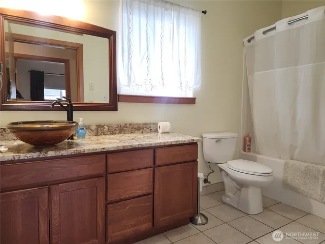 a bathroom with a granite countertop toilet a sink and a mirror