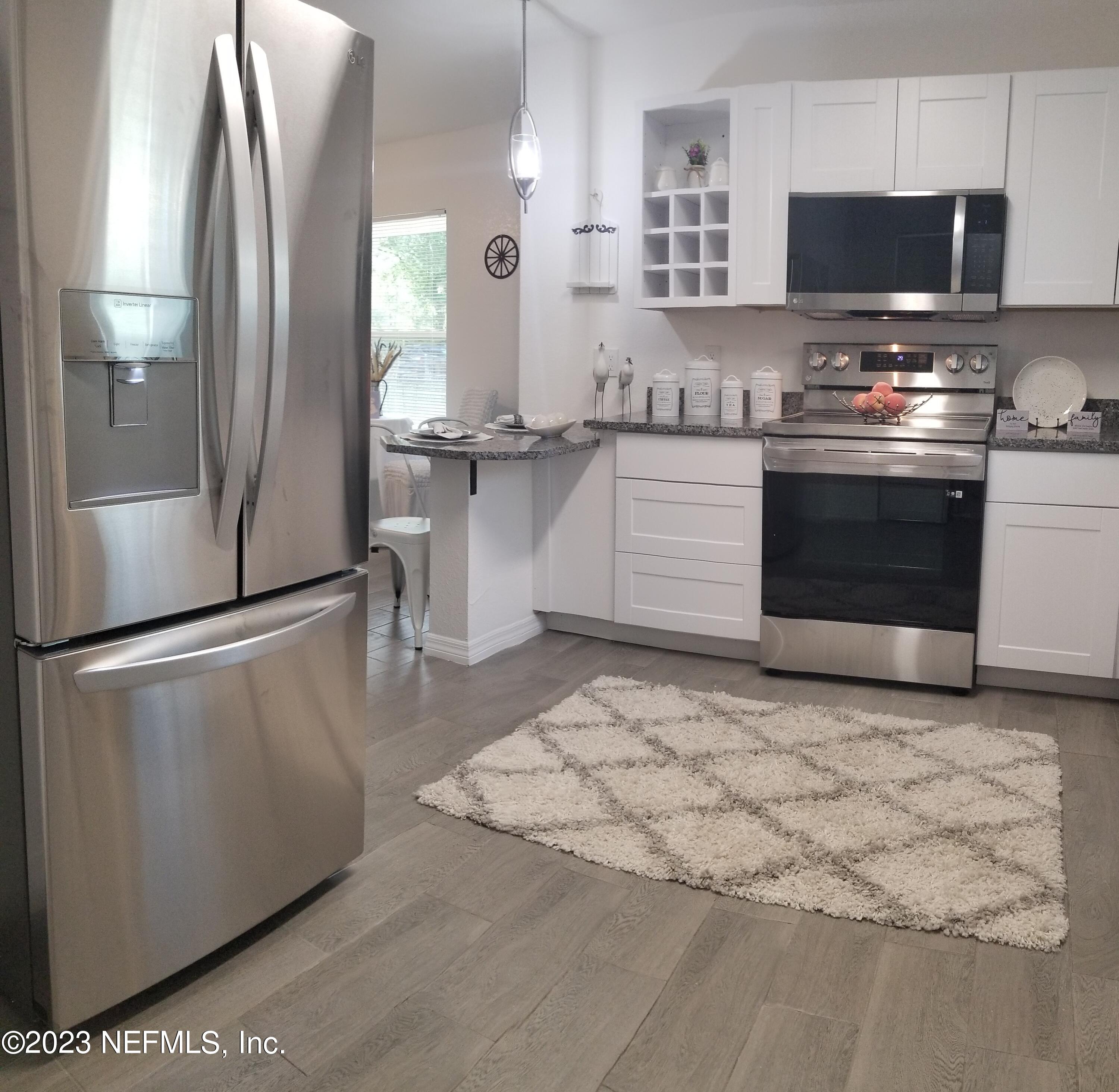 2116 Yulee Street Jacksonville, FL 32209 - Photo 4 of 12 a kitchen with stainless steel appliances granite countertop a refrigerator a stove and a sink